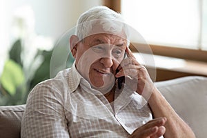 Smiling older man talking on phone, chatting with relatives