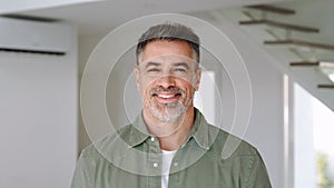 Smiling older mature man standing looking at camera at home. Portrait.