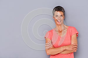 Smiling older woman against gray wall