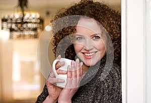 Smiling older woman holding cup of tea photo