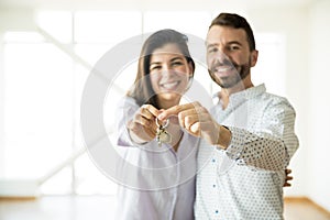 Smiling Owners Showing Keys Of Their New Apartment photo