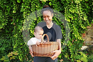Smiling Papuan mom with baby in wicked basket