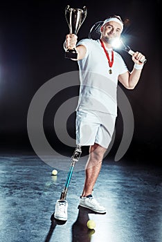 smiling paralympic tennis player showing champion goblet