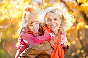 Smiling parent and kid family walking together outdoor in fall