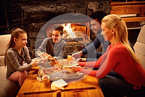 Smiling parents and children eating pizza together