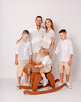 Smiling parents and three children on a white background. beautiful family