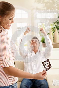 Smiling parents with ultrasound baby image