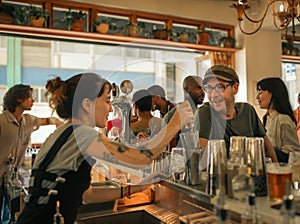 Smiling patron ordering drinks in a trendy bar