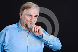 Smiling pensioner holding his hand on the beard