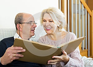 Smiling pensioners watching old photoes