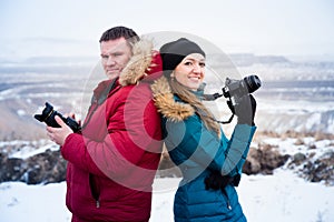 Smiling people with cameras in the hands of the mountains