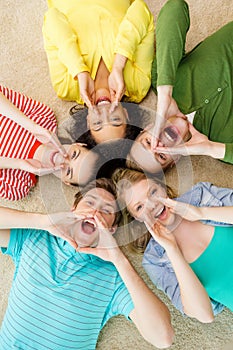 Smiling people lying down on floor and screaming