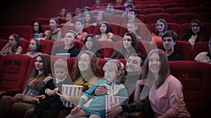 Smiling people watching movie in cinema