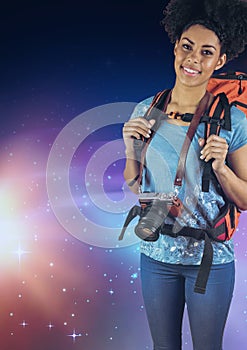 Smiling photographer with a backpack against galaxy background