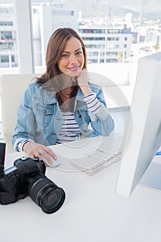 Smiling photographer editing at desk