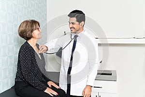 Smiling Physician Examining Patient In Hospital