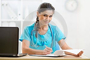 Smiling physician working in her office