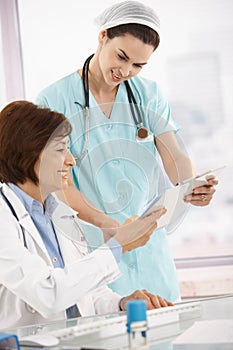 Smiling physician working with nurse