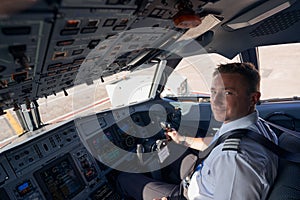 Smiling pilot posing for photo in cockpit