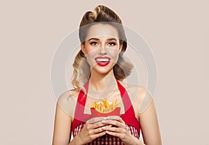 Smiling pin-up girl holding french fries in her hands