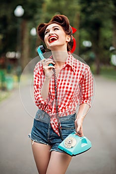 Smiling pinup girl with retro rotary phone