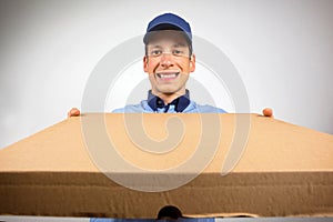 Smiling pizza delivery man holding pizza box