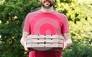 Smiling pizza delivery man holds pizza boxes outdoor. Mockup. Delivery service. Online order. Selective focus