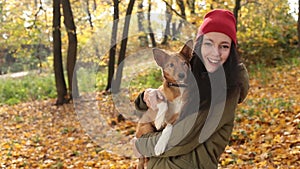 Smiling playful girl with dog on autumn day