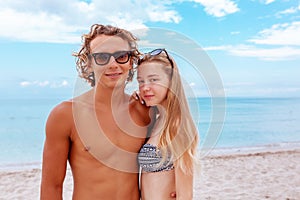 Smiling playful young couple in love having fun at sandy beach.