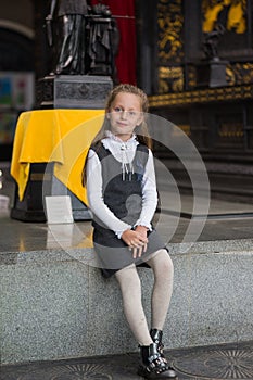 Smiling pleasantly cheerful positive girl regarding ancient statues in museum photo