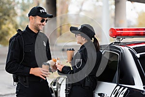 Smiling police officer holding takeaway coffee