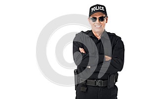 Smiling policeman wearing uniform with arms folded