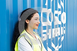 Smiling portrait of beautiful asian female industrial engineer wearing white helmet, vest holding walkie talkie. Safety Supervisor