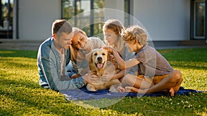 Smiling Portrait of Beautiful Family of Four Having Picnic on the Lawn, Posing with Happy Golden R