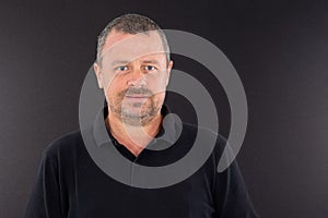 Smiling portrait middle aged man isolated on black shirt and background