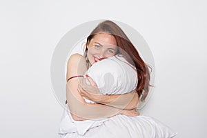 Smiling portrait of a woman leaning on a pillow over white background