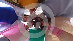 Smiling portrait of young college student friends in circle looking at camera