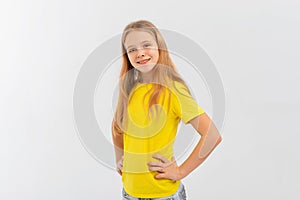 Smiling positive, attractive teen girl wearing casual yellow tshirt, feeling happy looking to camera standing isolated on white