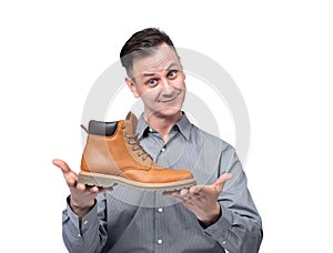 Smiling positive businessman seller holding a shoe in his hands, isolated on white background