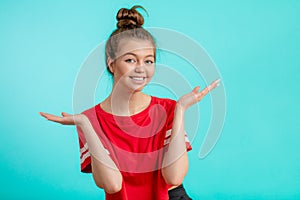 Smiling positive girl with hairbun presenting new product.