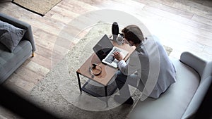 Smiling positive professional businessman working on laptop computer at home