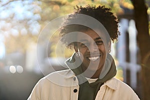 Happy young gen z African American teen standing at sunny city park. Portrait