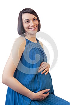 Smiling Pregnant Caucasian Brunette Woman Posing in Light Blue Dress Against Pure White Background While Smiling and Looking to