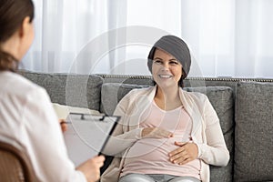 Smiling pregnant woman consult with doctor in hospital