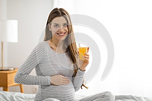 Smiling pregnant woman with a glass of juice