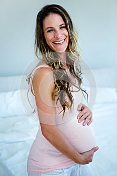 smiling pregnant woman holding her bump