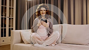 Smiling pregnant woman holding ultrasound scan