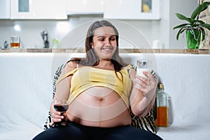 Smiling pregnant woman looking at milk