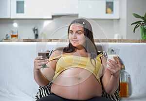 Smiling pregnant woman looking at milk