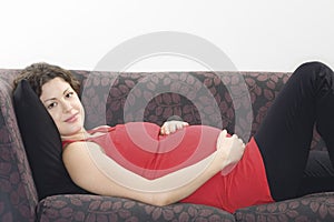 Smiling Pregnant Woman Relaxing On Sofa